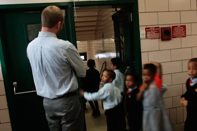Teacher Shawn Abernathy supervises students in the hallway as they head upstairs at Harlem Success Academy in 2009